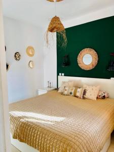 a bedroom with a large bed with a green wall at Apartment with views of sea and mountains in Taurito