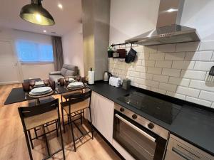 a kitchen with a counter and a table with chairs at Apartamento Xogo da Ola En el camino De Santiago in Porriño