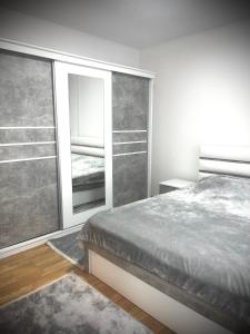 a bedroom with a bed and a large window at Falcon Apartment in Brezovicë