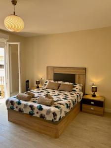 a bedroom with a large bed with two lamps on tables at Apartamentos vinarós a 300m de la playa in Vinarós