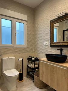 a bathroom with a sink and a toilet and a mirror at Apartamentos vinarós a 300m de la playa in Vinarós +35 photos