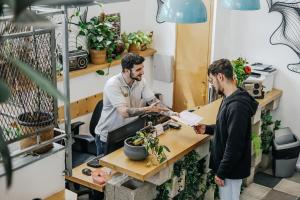 two men standing at a desk in an office interviewing a man at Domus Metro Hotel in Tel Aviv