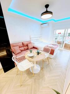 Una sala de estar con un sofá, una mesa y sillas. en Luxury studio Torremolinos Costa del Sol, en Torremolinos