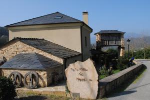 un pequeño edificio de piedra con techo en una calle en A Casa de Mañas en Mondoñedo