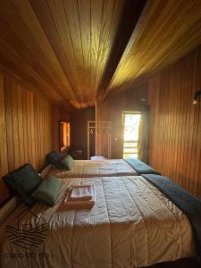 a bedroom with a large bed with a wooden ceiling at Casa do Rio, Sever do Vouga in Paradela