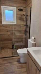 Un baño con ducha, inodoro y lavabo. en Passive House con piscina y jardín privado, en Novo Sancti Petri