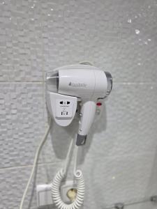 a hair dryer on a wall in a bathroom at Cabo Apparte Piscine & Panoramique View K17 in Cabo Negro