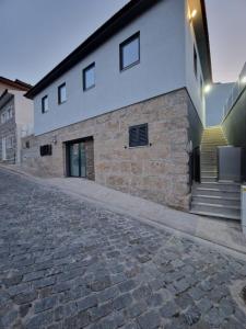 an empty cobblestone street in front of a building at Douro VALLEY- Casa da Madrinha in Escamarão
