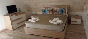 una camera da letto con un letto con asciugamani sopra di Casa del viaggiatore a Molfetta Altre 47 foto