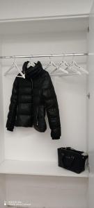 una giacca nera e una borsa nera in un armadio di Casa del viaggiatore a Molfetta