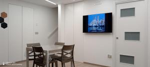 una sala da pranzo con un tavolo e una TV a parete di Casa del viaggiatore a Molfetta