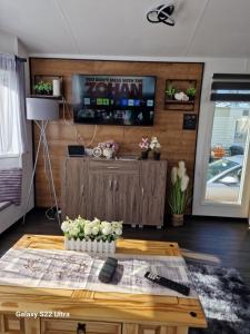 a living room with a coffee table and a tv at Forest Valley Holiday Home in Ballantrae