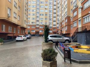 a parking lot with cars parked in front of a large building at Relax and Explore the City in Chişinău