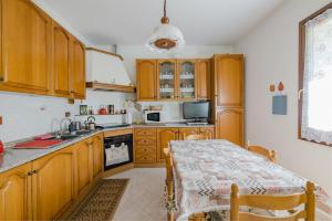 a kitchen with wooden cabinets and a table with a tablecloth at B&B CA'di Beppe in Madonna di Fornelli