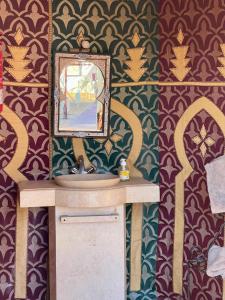 a bathroom with a sink and a mirror at Moroccan Desert Camp in Merzouga