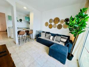 a living room with a blue couch and a kitchen at Little Gem in Matagorda