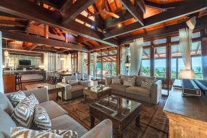 a living room with couches and a table at Villa Gecko with sea view pool, walk to Beach & Restaurants in Surin Beach