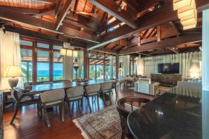 a living room with a dining room table and chairs at Villa Gecko with sea view pool, walk to Beach & Restaurants in Surin Beach