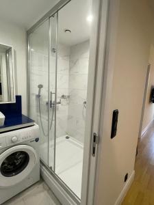 a bathroom with a shower and a washing machine at Sea View Apartment in Batumi +63 photos