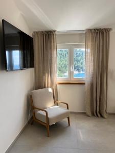 une chaise assise dans une pièce avec fenêtre dans l'établissement Villa Ljeto, à Pupnatska Luka