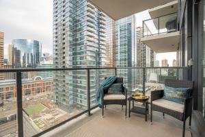 a balcony with two chairs and a view of a city at Stylish Condo with Exclusive Rooftop Pool in Calgary