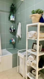 ein Badezimmer mit einem weißen Regal mit Handtüchern und einer Badewanne in der Unterkunft The Pradise of Ana Vemar Exclusive Apartament in Playa Paraiso