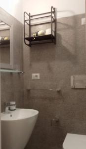 a bathroom with a sink and a toilet and a shelf at Cinghiale Bianco in Cagliari +11 photos