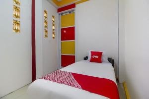 a room with a bed with a red pillow on it at Hotel O Restu Inn in Lampung