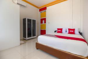 a bedroom with a bed with red pillows on it at Hotel O Restu Inn in Lampung