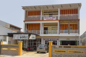 a building with a car parked in front of it at Hotel O Restu Inn in Lampung