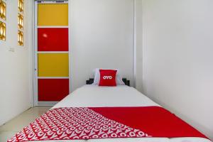 een slaapkamer met een rood kussen op een bed bij Restu Inn in Lampung
