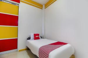 een slaapkamer met een bed met een rood kussen erop bij Restu Inn in Lampung +34 foto's