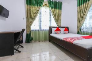 une chambre avec un lit, un bureau et une fenêtre dans l'établissement Hotel O Bukit Somber Residence Syariah, à Kampung Baru