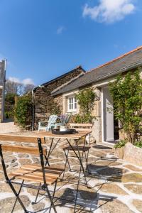 - une terrasse avec une table et des chaises en face d'un cottage dans l'établissement TY LAOUEN - Maison bretonne de charme avec sauna, à Plougonvelin