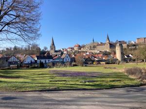 a town with a field of grass and buildings at Ferienwohnung -Diemelaue- in Warburg