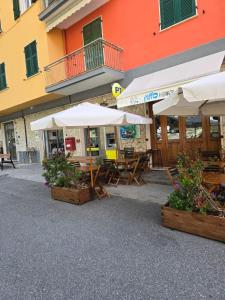 a restaurant with tables and umbrellas in front of a building at Pippo a Vernazza Rooms in Vernazza