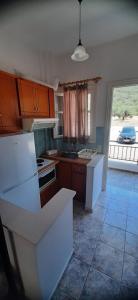 a kitchen with white appliances and a large window at MAKRIS Studios in Yiáltra