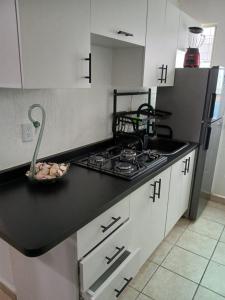 a kitchen with a stove top and a sink at Autentico y Lindo Departamento in Puerto Vallarta