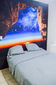 a bed in a room with a painting on the wall at Autentico y Lindo Departamento in Puerto Vallarta