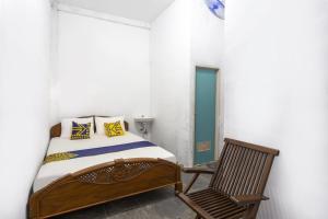 a bedroom with a bed and a chair at Hotel O near Metropolitan Mall formerly Sakura Home Stay in Kaum