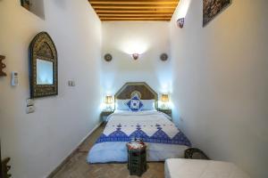 a bedroom with a bed and a mirror in a room at Dar Mchachti fes in Fès