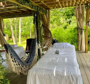 a porch with two beds and a porch swing at Cape Cod Villa in Harwich