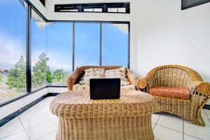 a room with two wicker chairs and a table with a laptop at Collection O Puncak Near Kota Bunga Formerly Villa Gunung Agape in Tjiandjur