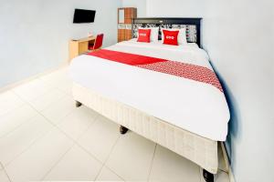 a bedroom with a large bed with red pillows at OYO Life 3982 Azka Homestay Syariah in Bandar Lampung +19 photos