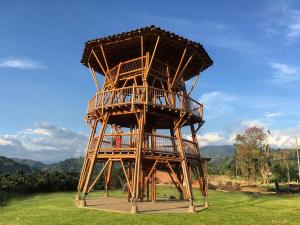 a wooden tower sitting on top of a grass field at COMODO ESTUDIO VIA A TERMALEs in Santa Rosa de Cabal