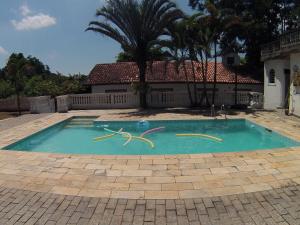 a swimming pool with yellow handles in the middle at Chácara c piscina e churrasqueira em sta isabel in Santa Isabel