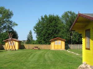a yard with two small yellow buildings and a playground at Kolkja Holiday Centre in Kolkja