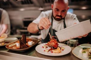 a chef is preparing food in a restaurant kitchen at OYO The Leven in Stokesley