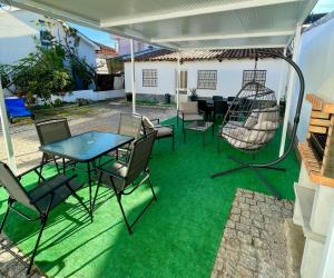 a patio with a table and chairs and a swing at Alojamento Local Afonso in Macedo de Cavaleiros