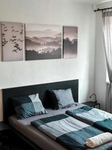 a bedroom with a bed with four pictures on the wall at ADM Historic Center Apartment - NETFLIX,Coffee, AC in Bratislava +9 photos